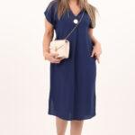 Granatowa sukienka z rozcięciami po bokach i broszką